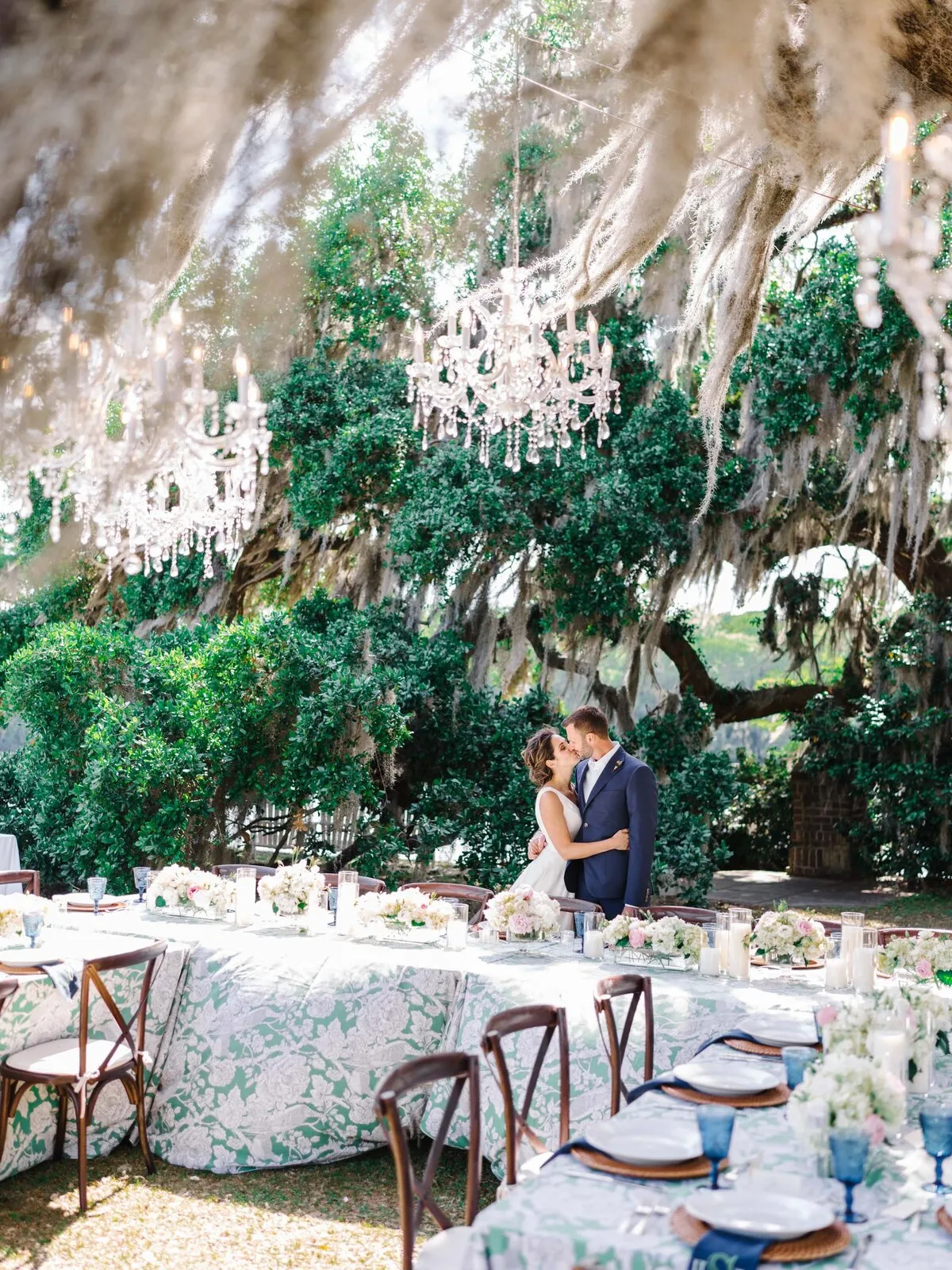 Wedding reception tablescape under Spanish moss and chandeliers in Charleston SC