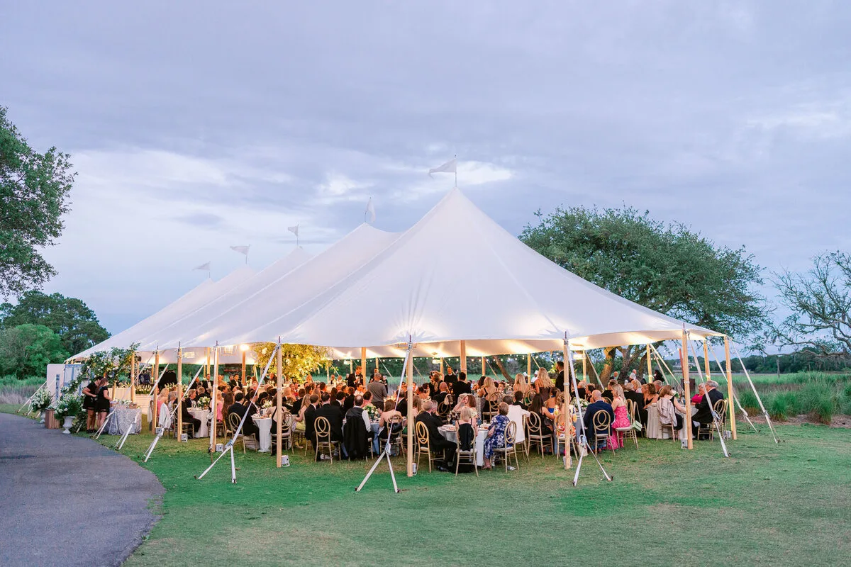 Tented wedding reception glowing at dusk in the Charleston Lowcountry