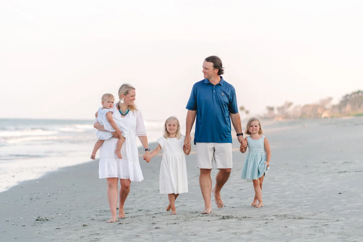 Family walking along the shoreline at DeBordieu Beach in Georgetown SC