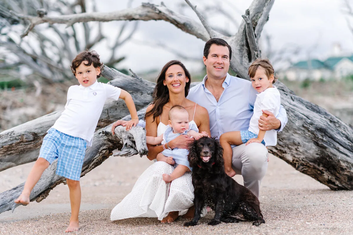 Family with a dog on the driftwood log at DeBordieu Beach