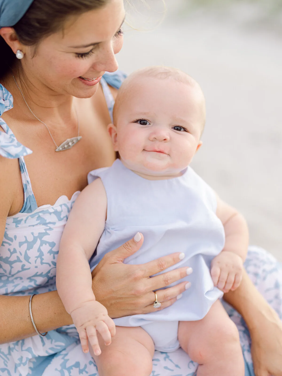 Mother holding her baby boy in blue at DeBordieu Beach