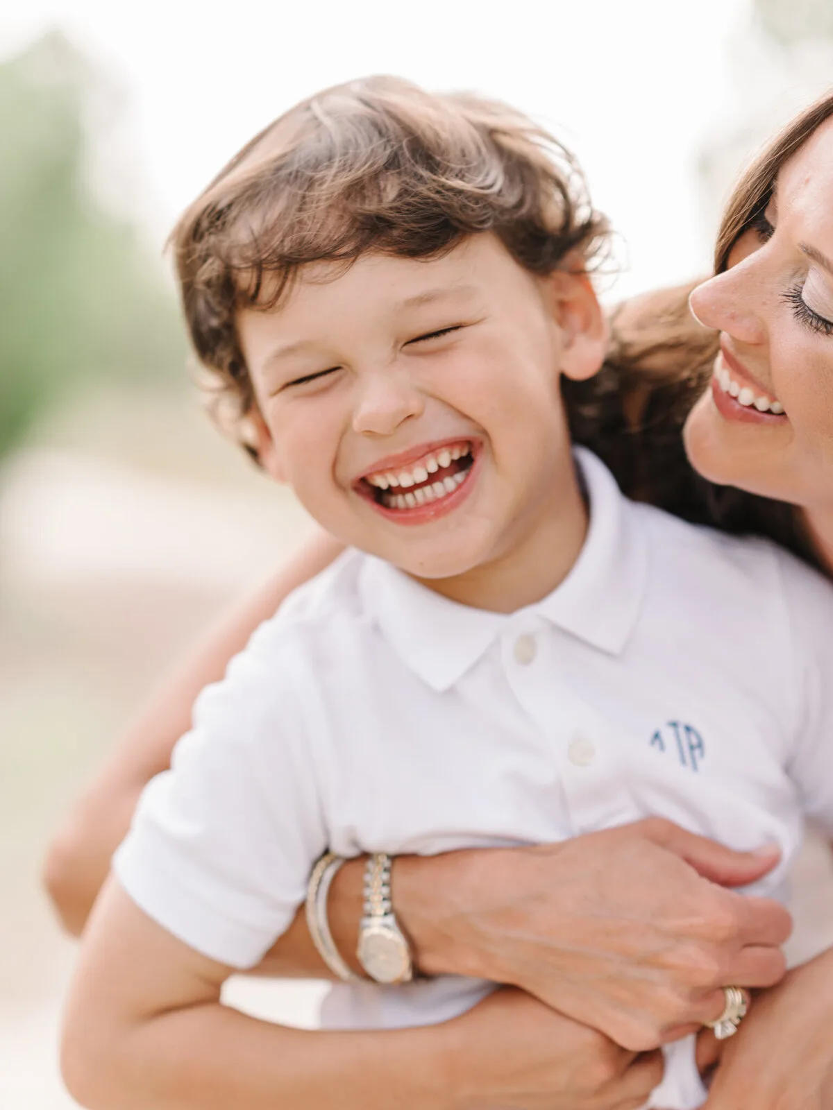 Mother hugging her laughing son on DeBordieu Beach