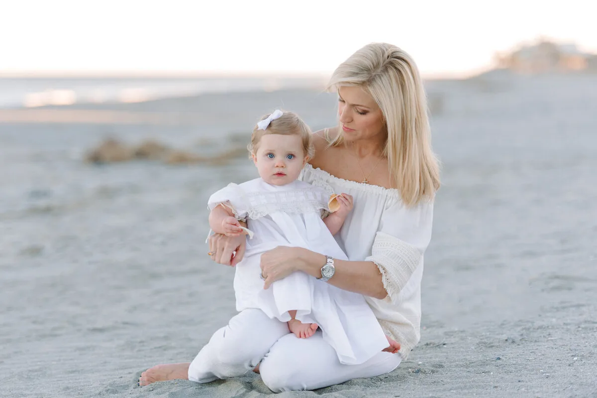 Mother sitting with her baby on DeBordieu Beach in Georgetown SC