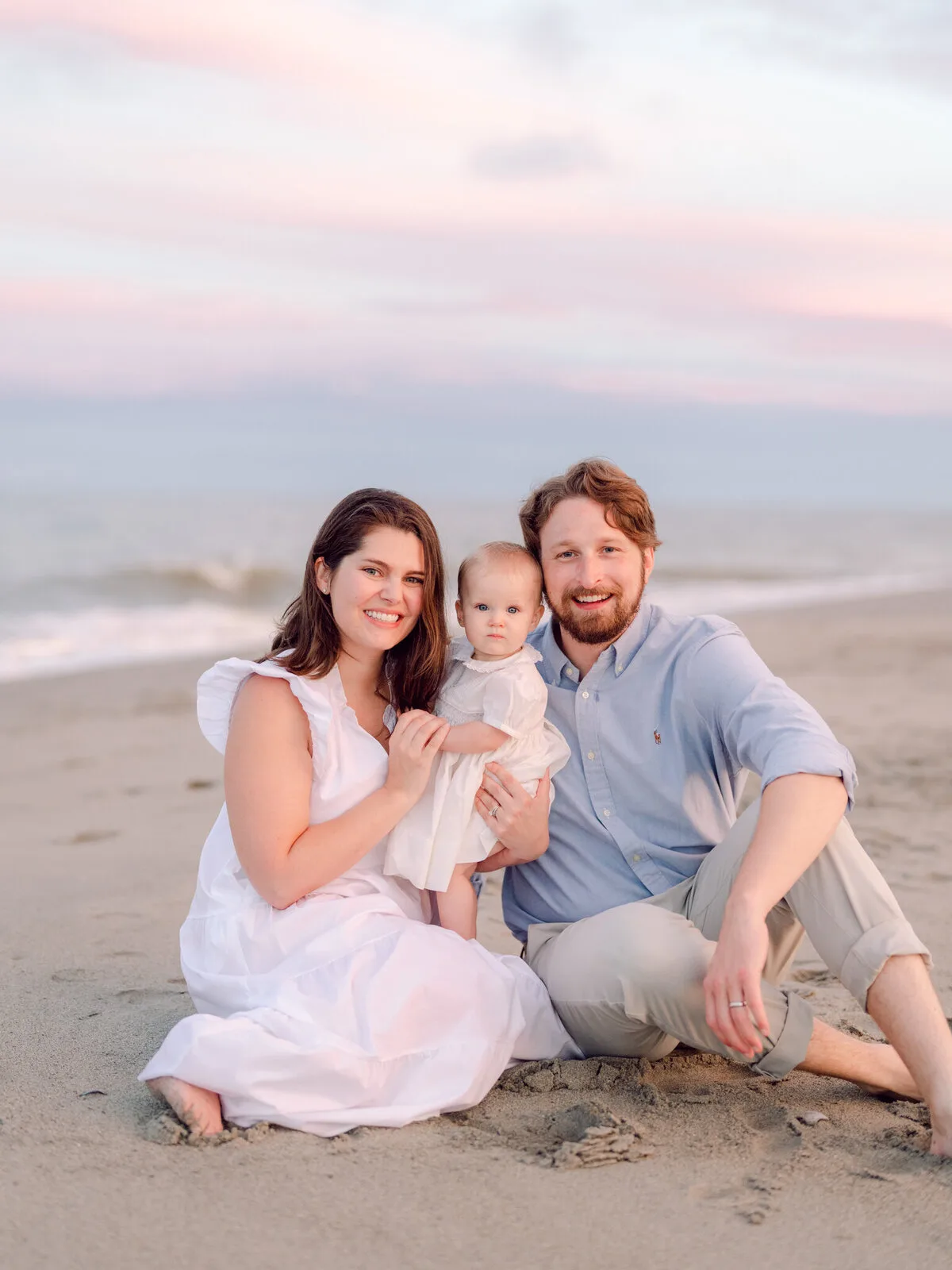 Parents and baby sitting on the sand at DeBordieu Beach