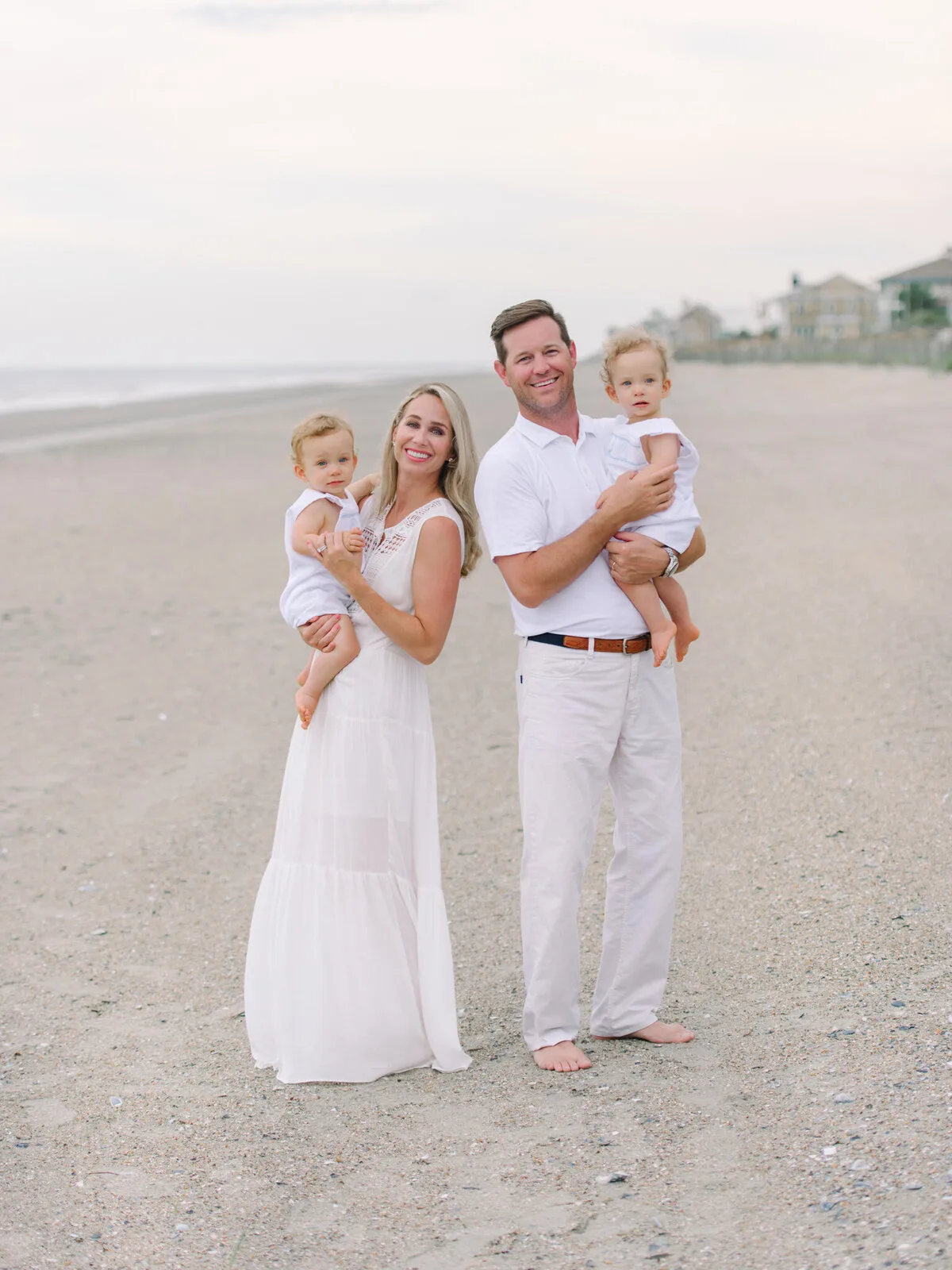 Parents holding their babies on the beach at DeBordieu in Georgetown SC