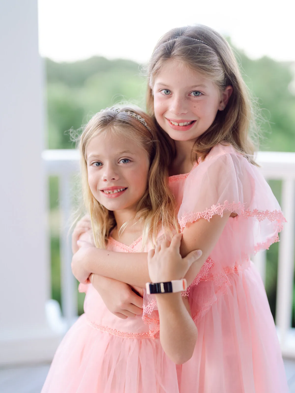 Sisters hugging in pink dresses at DeBordieu Beach