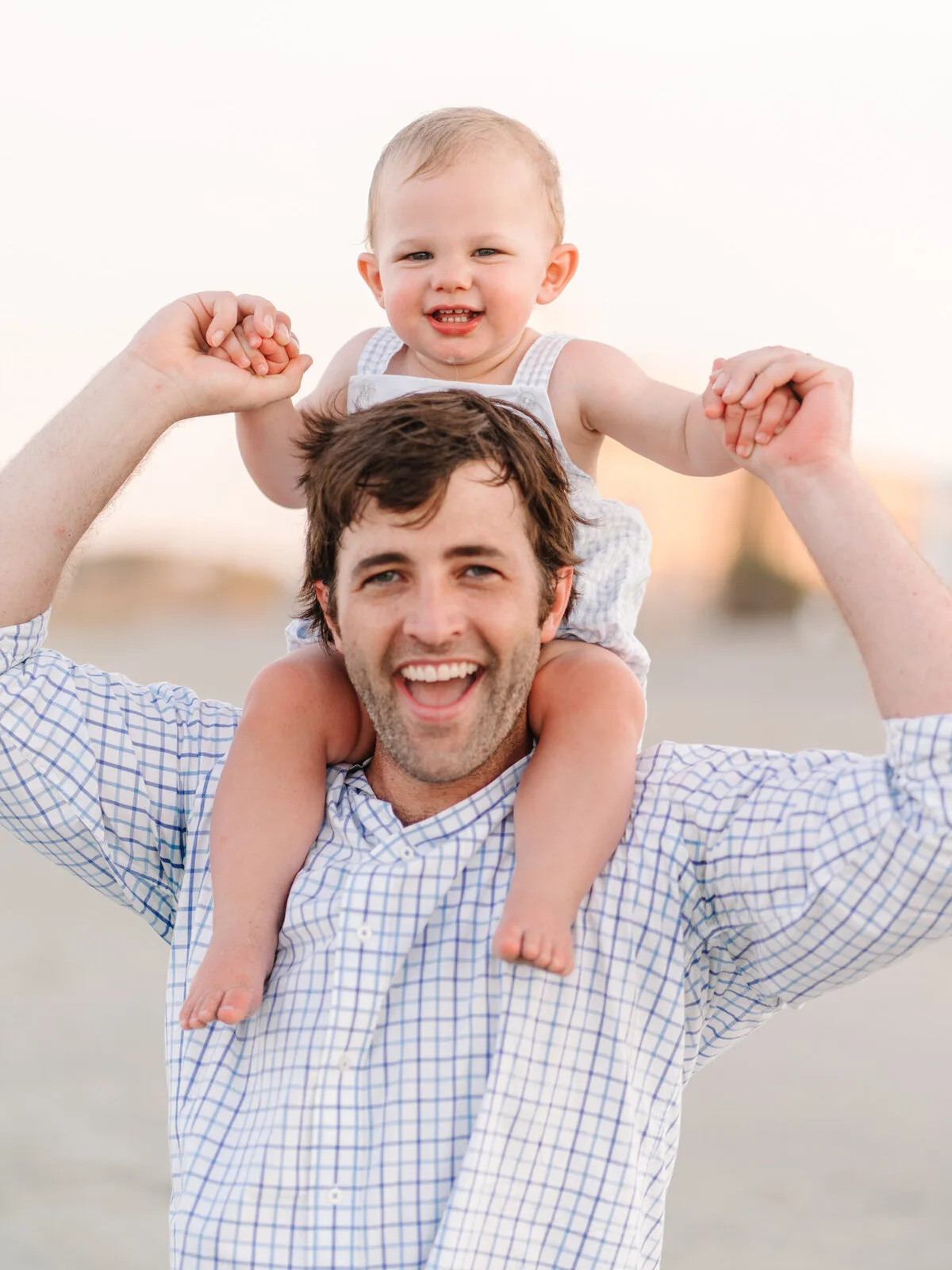 Dad with his baby on his shoulders laughing in Garden City Beach SC