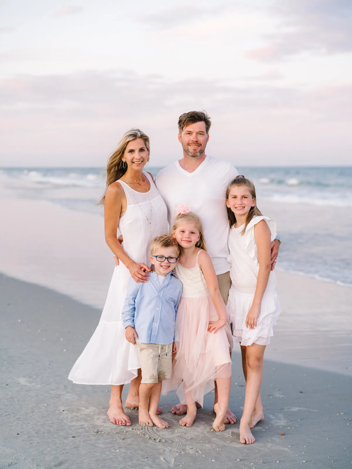 Family of five in pastel colors at sunset in Garden City Beach SC