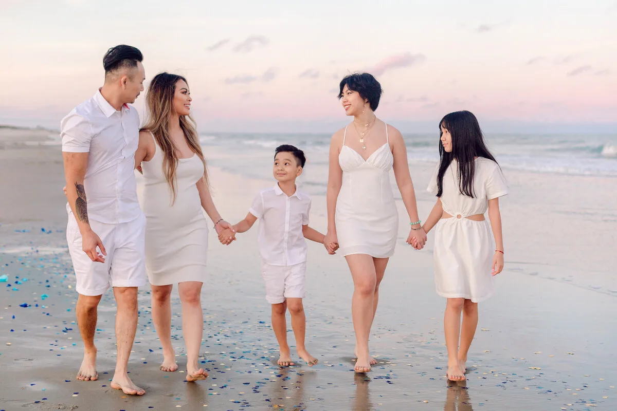 Family walking hand in hand at dusk in Garden City Beach SC