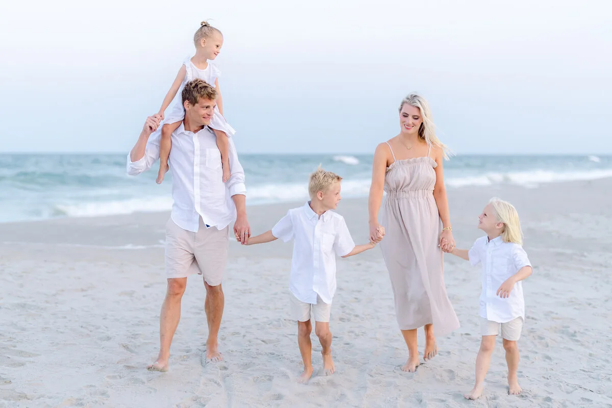 Family walking with a child on dads shoulders in Garden City Beach SC