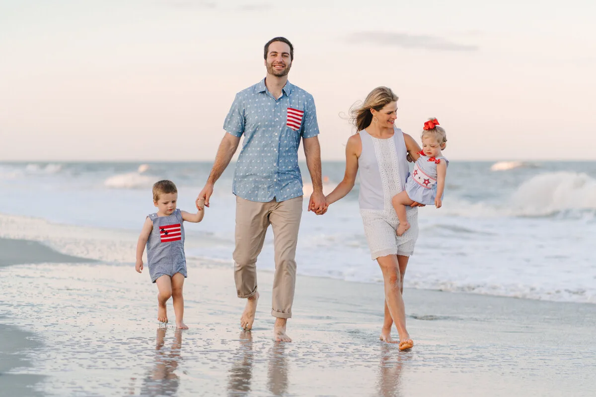 Parents walking with their children at sunset in Garden City Beach SC
