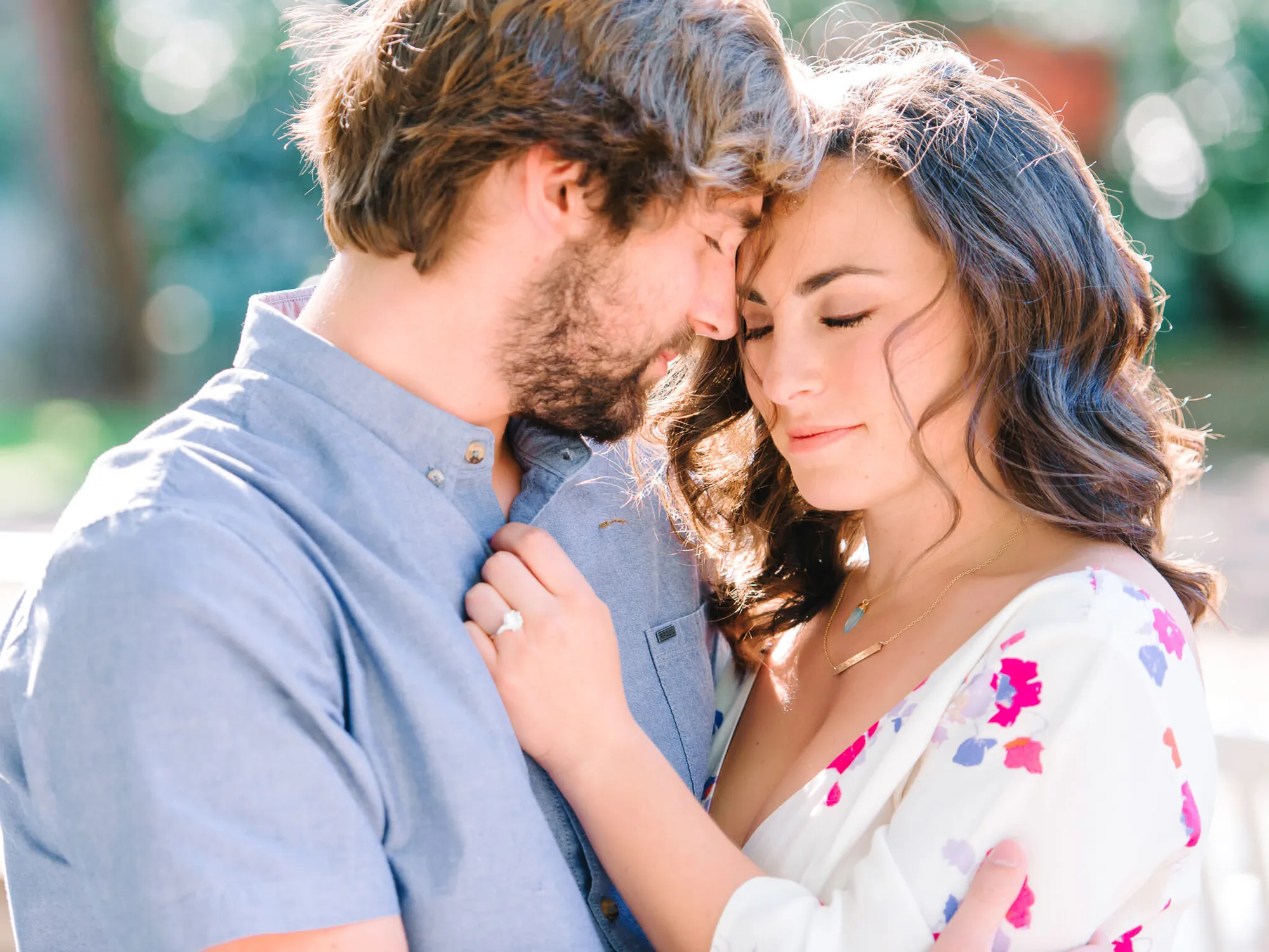 Close engagement portrait of a couple forehead to forehead, his hand on her shoulder with her engagement ring showing, in Myrtle Beach