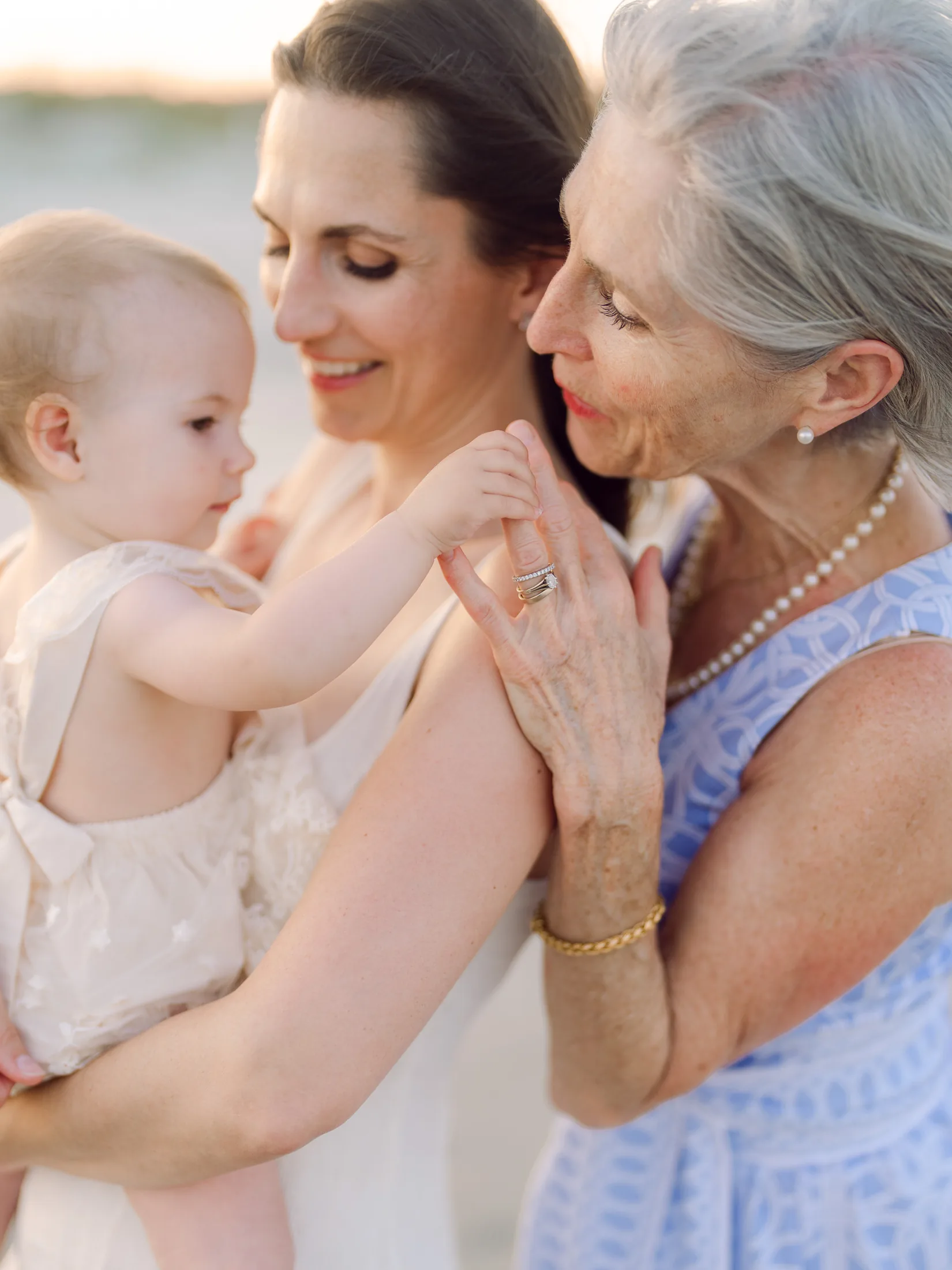 Three generations portrait of a grandmother, mother and baby on the beach