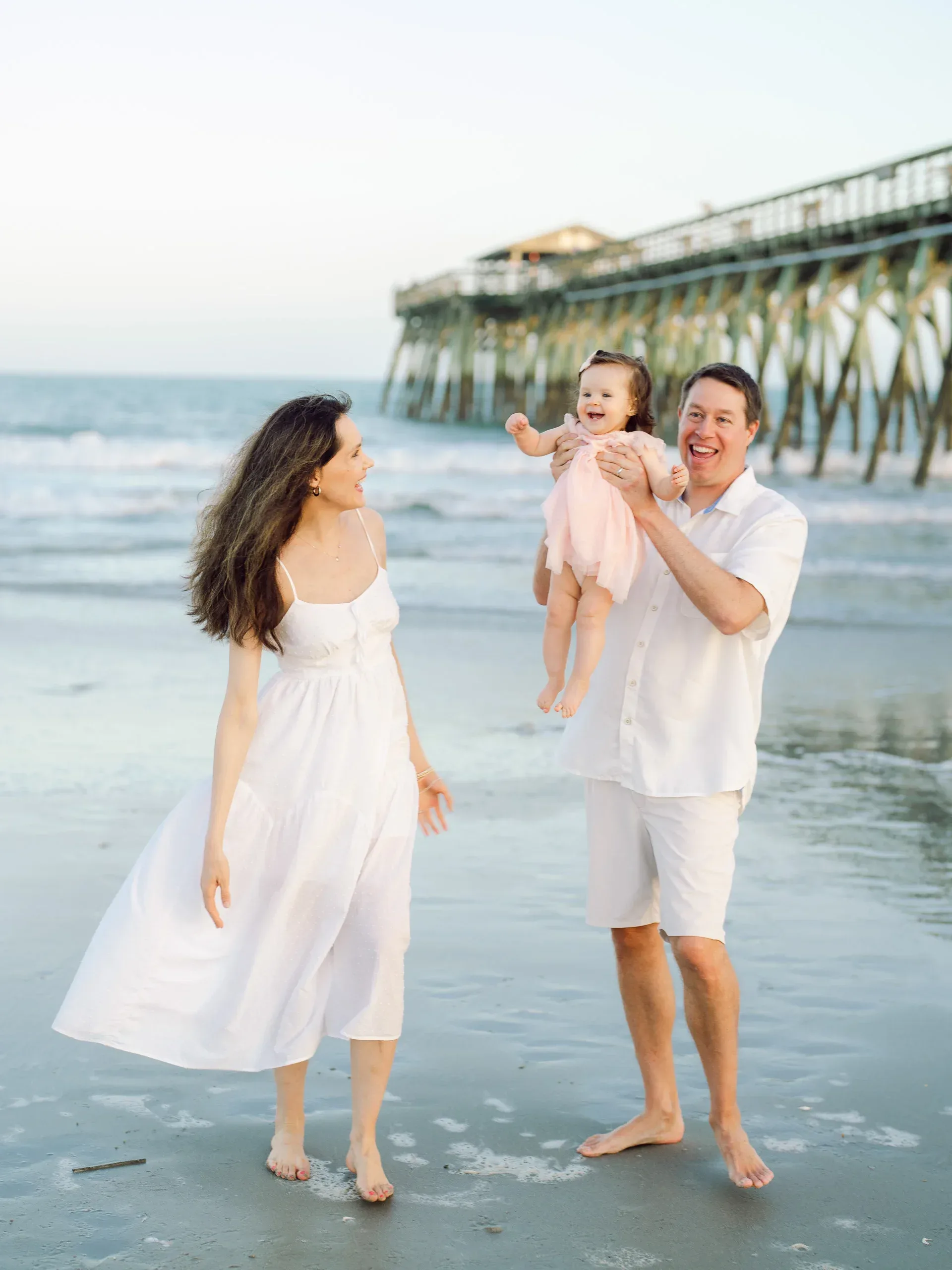 Family close together on the sand by Pasha Belman Photography