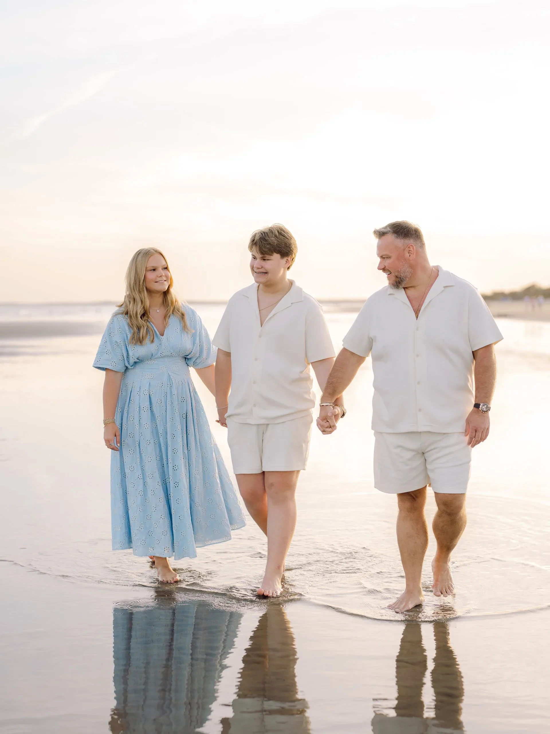 Family walking the shoreline together by Pasha Belman Photography