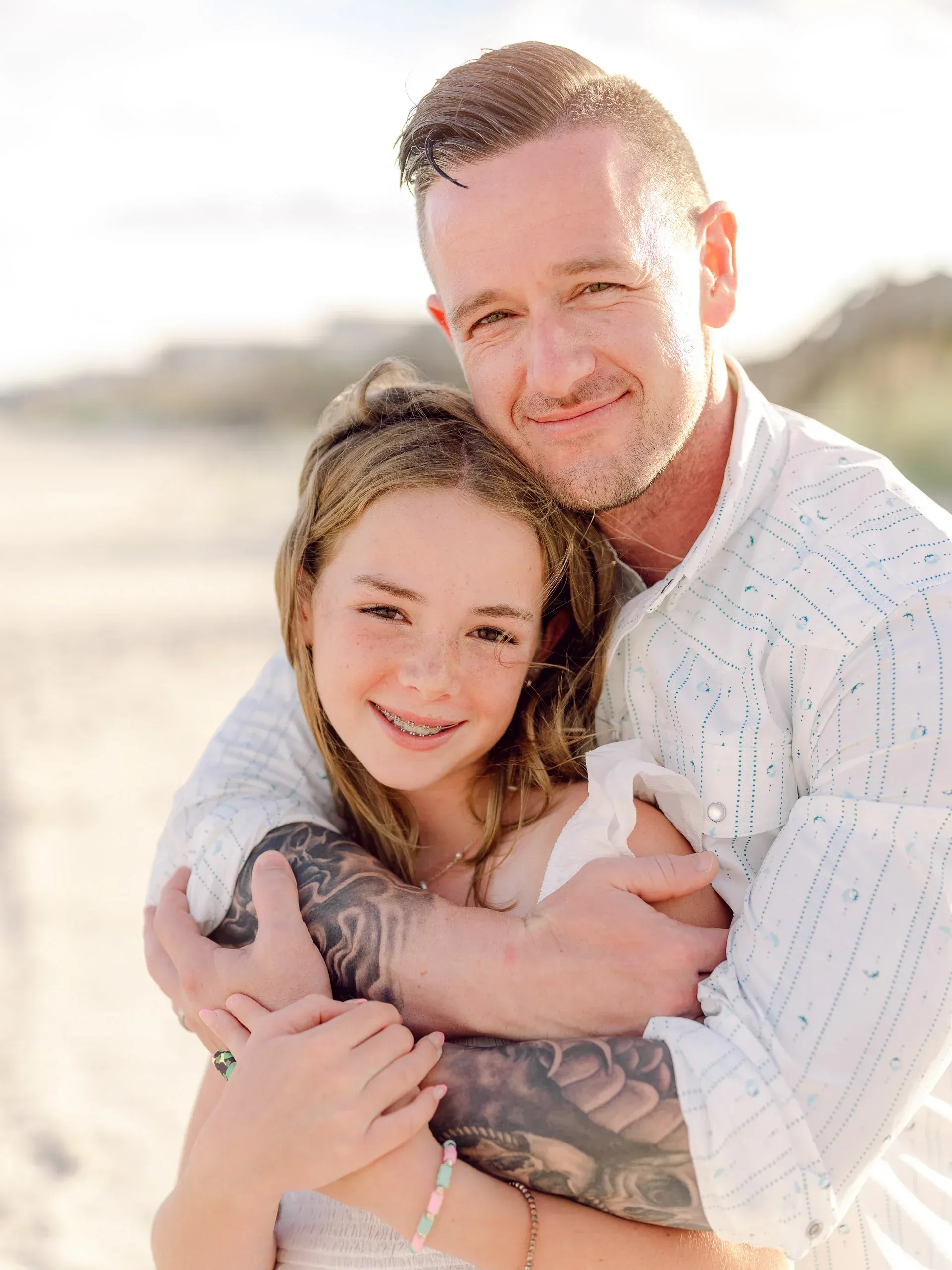 Father hugging his daughter at sunset by Pasha Belman Photography
