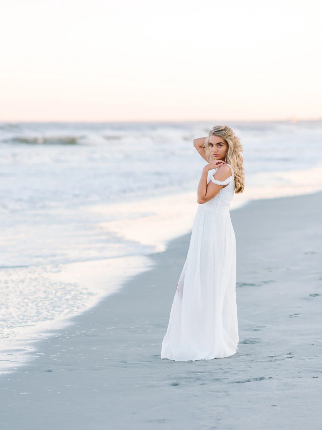 Senior in a white dress on an empty Myrtle Beach shoreline