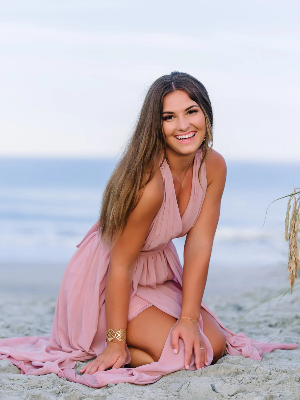 Senior sitting on the sand in a pink dress, Myrtle Beach senior pictures
