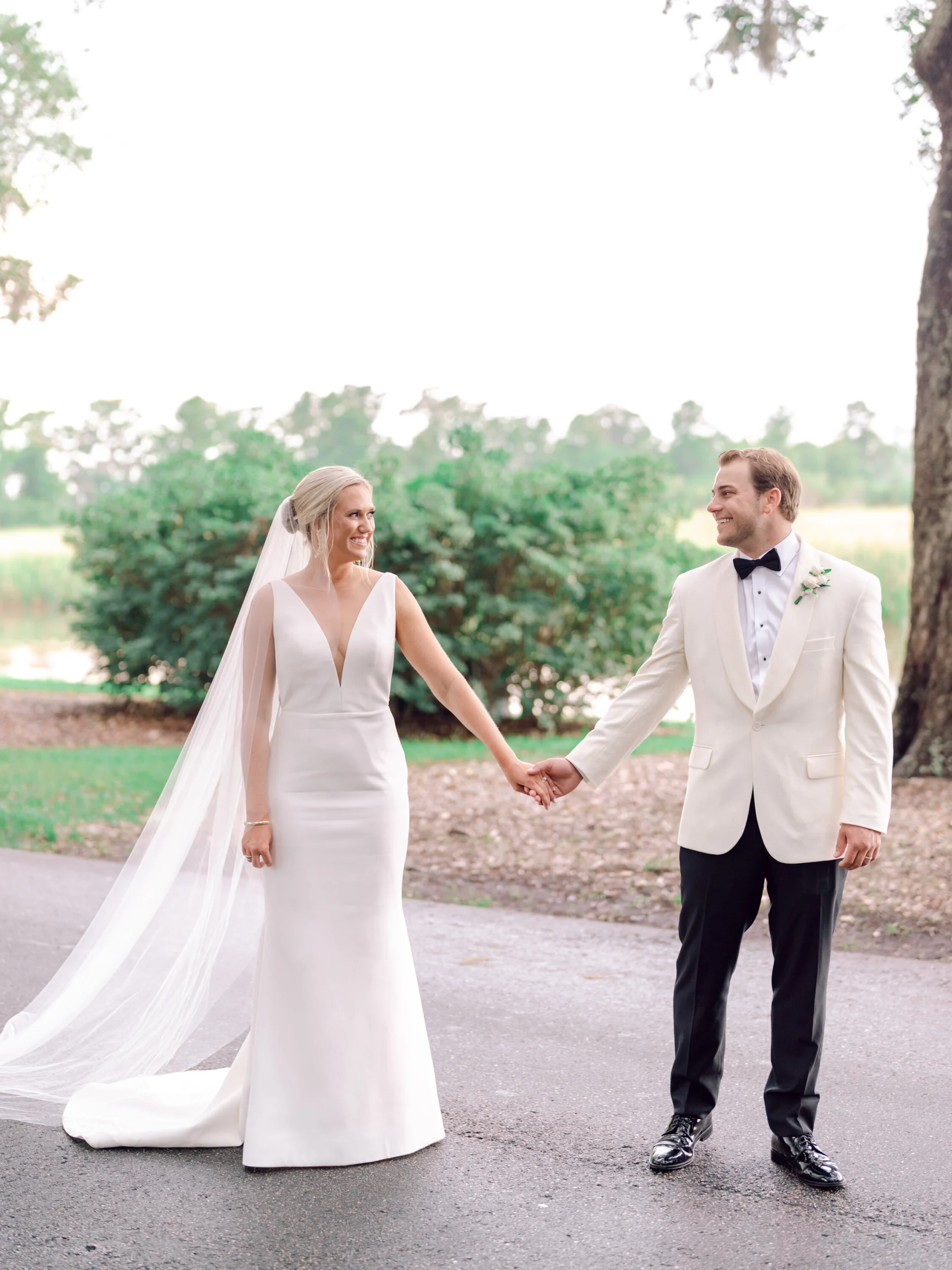 Bride and groom holding hands on the lawn at Caledonia Golf and Fish Club, Myrtle Beach wedding photographers