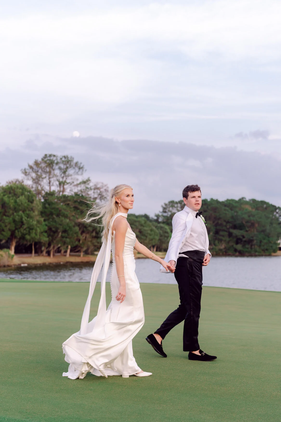 Bride and groom walking by the water at sunset, Grand Strand wedding