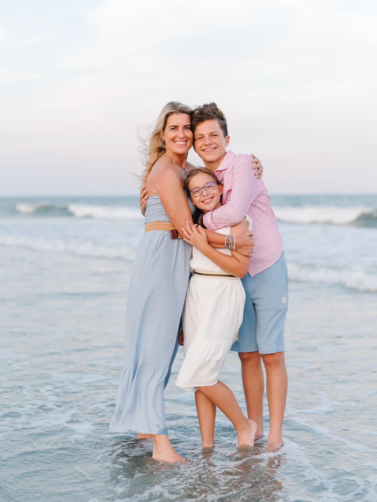 Family hugging in the waves on a North Myrtle Beach family photo session