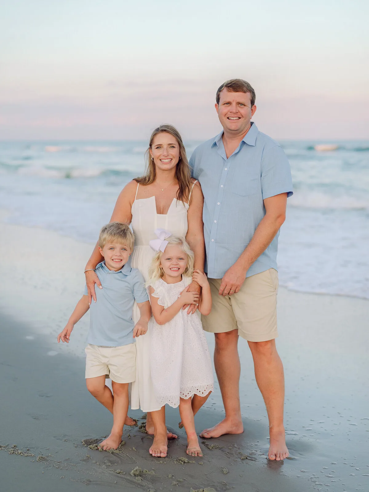 Family of four standing at the shoreline in North Myrtle Beach