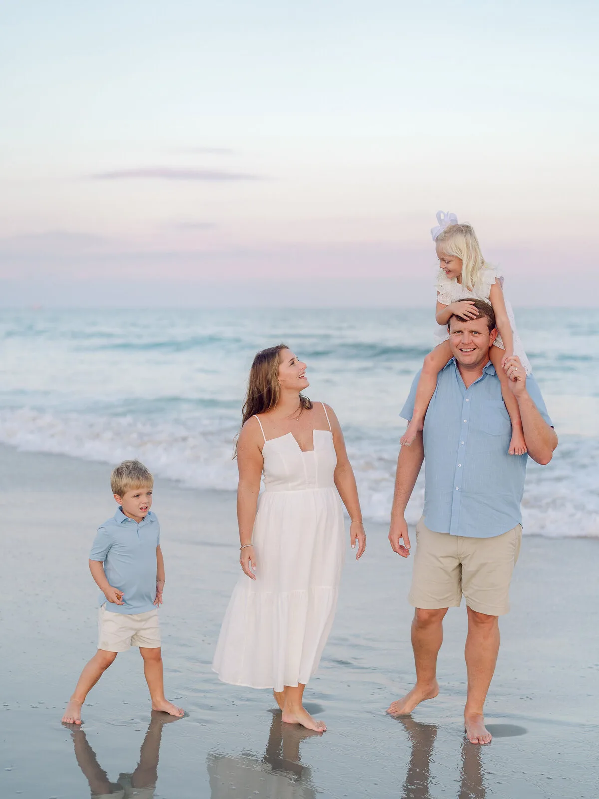 Family walking on the beach with a child on dad's shoulders in North Myrtle Beach