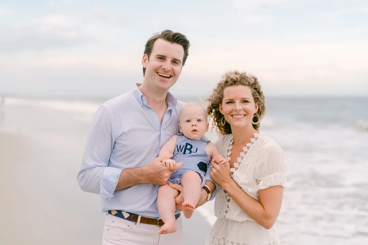 Parents and baby boy smiling on the beach in North Myrtle Beach