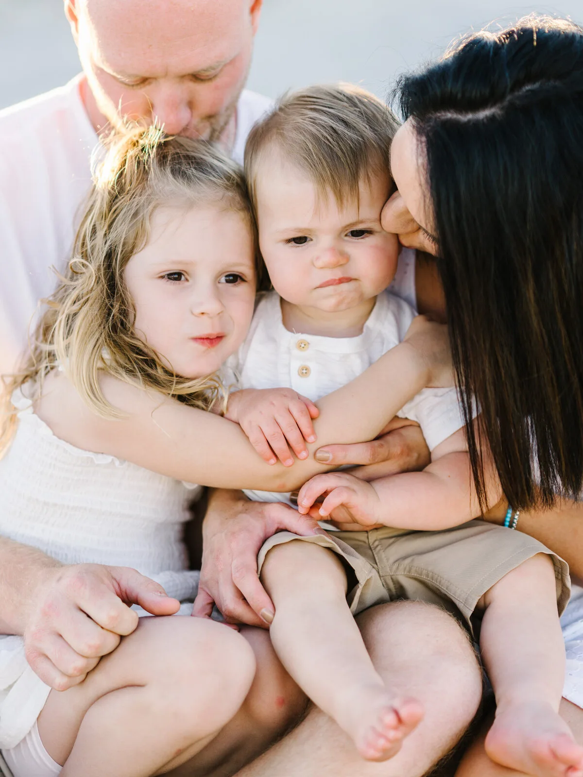 Parents kissing their baby and toddler in a close-up family portrait in North Myrtle Beach