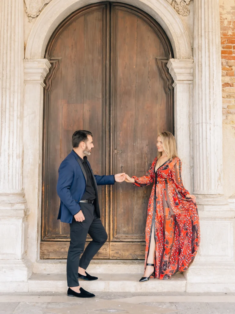 Pasha and Natallia Belman by an old wooden door in Venice, Italy