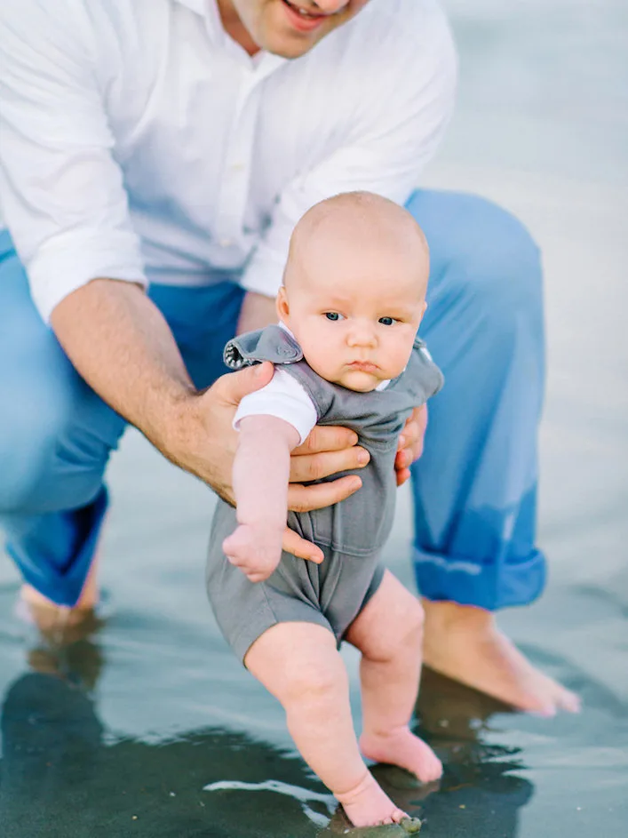 Dad holding his baby boy in the surf at Pawleys Island beach
