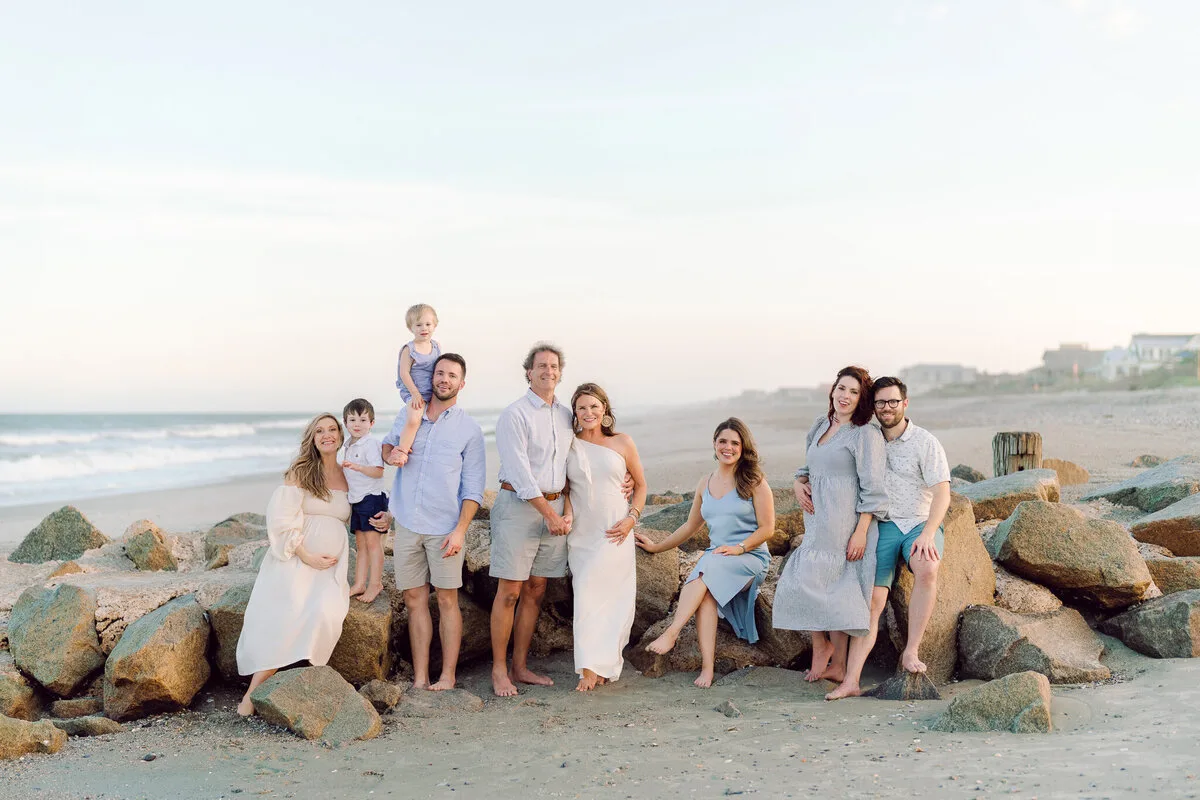 Large family gathered on the rocks for a sunset beach portrait in Pawleys Island SC