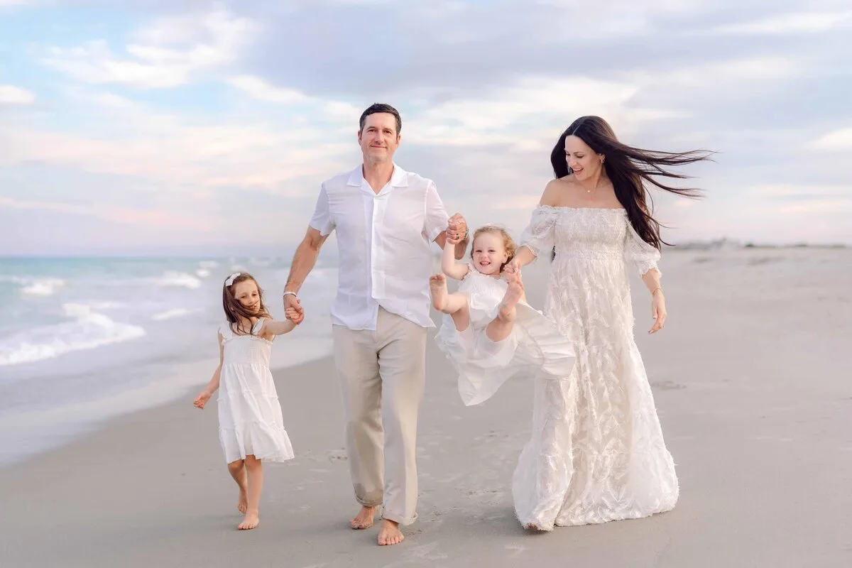 Family walking the shoreline at sunset in Pawleys Island South Carolina