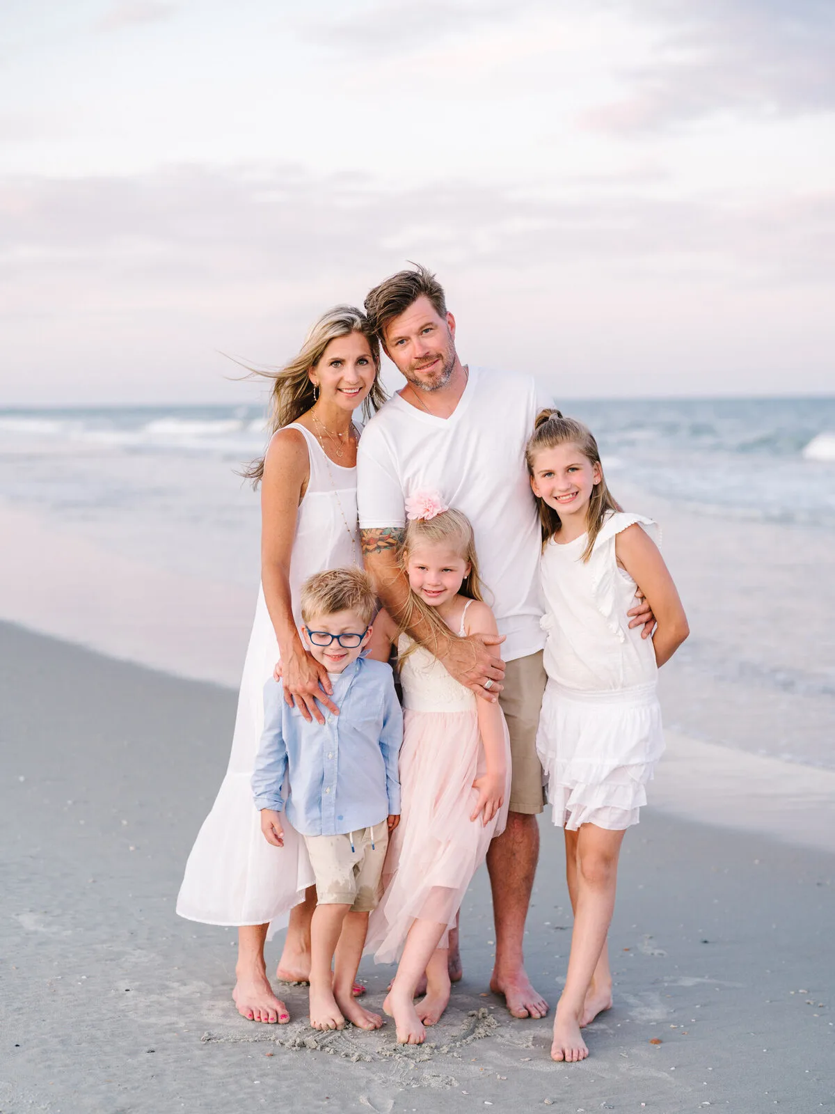 Parents and daughters hugging on the beach in Pawleys Island