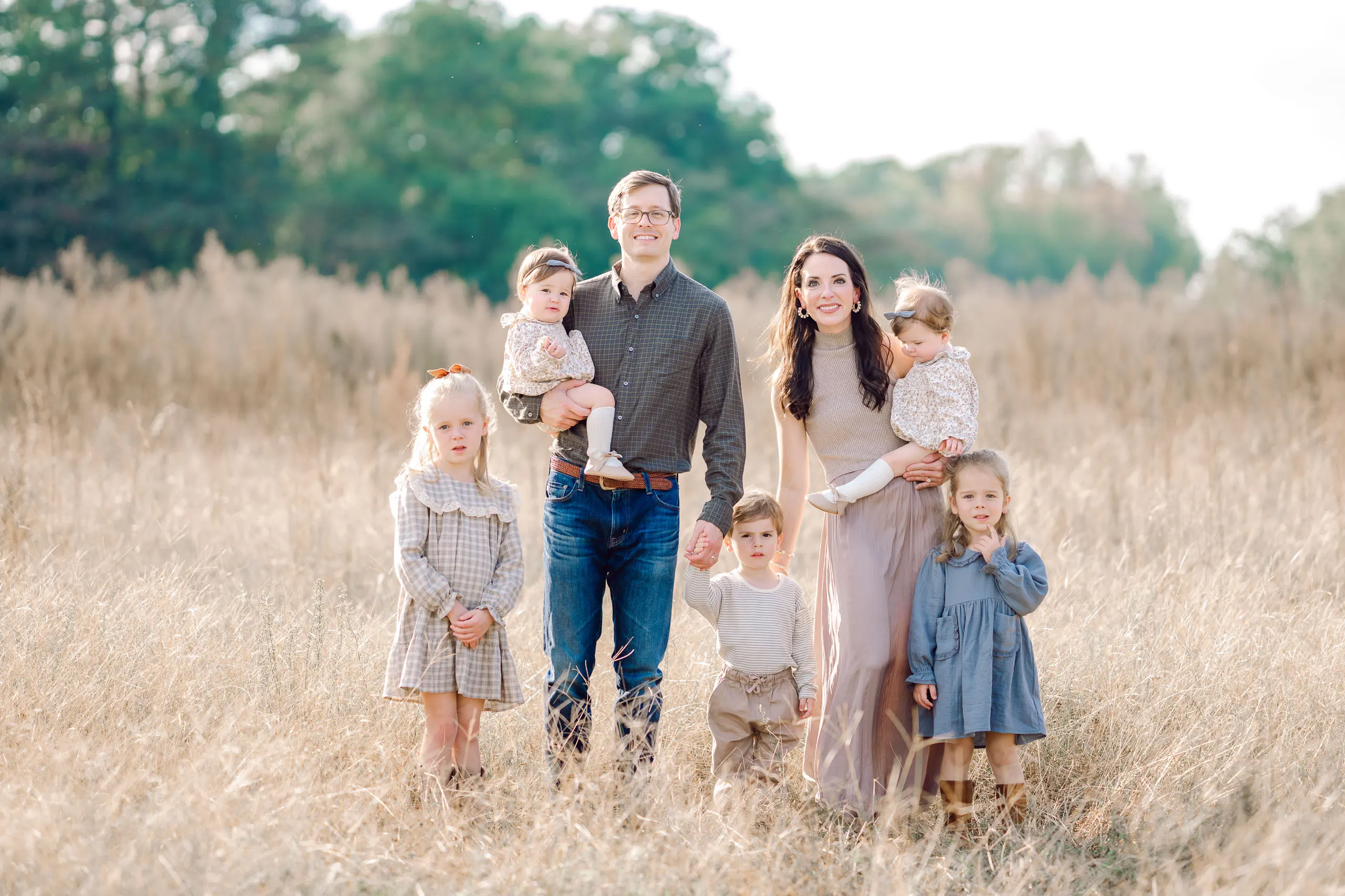 Family of seven standing together in a golden field in Pinehurst, North Carolina
