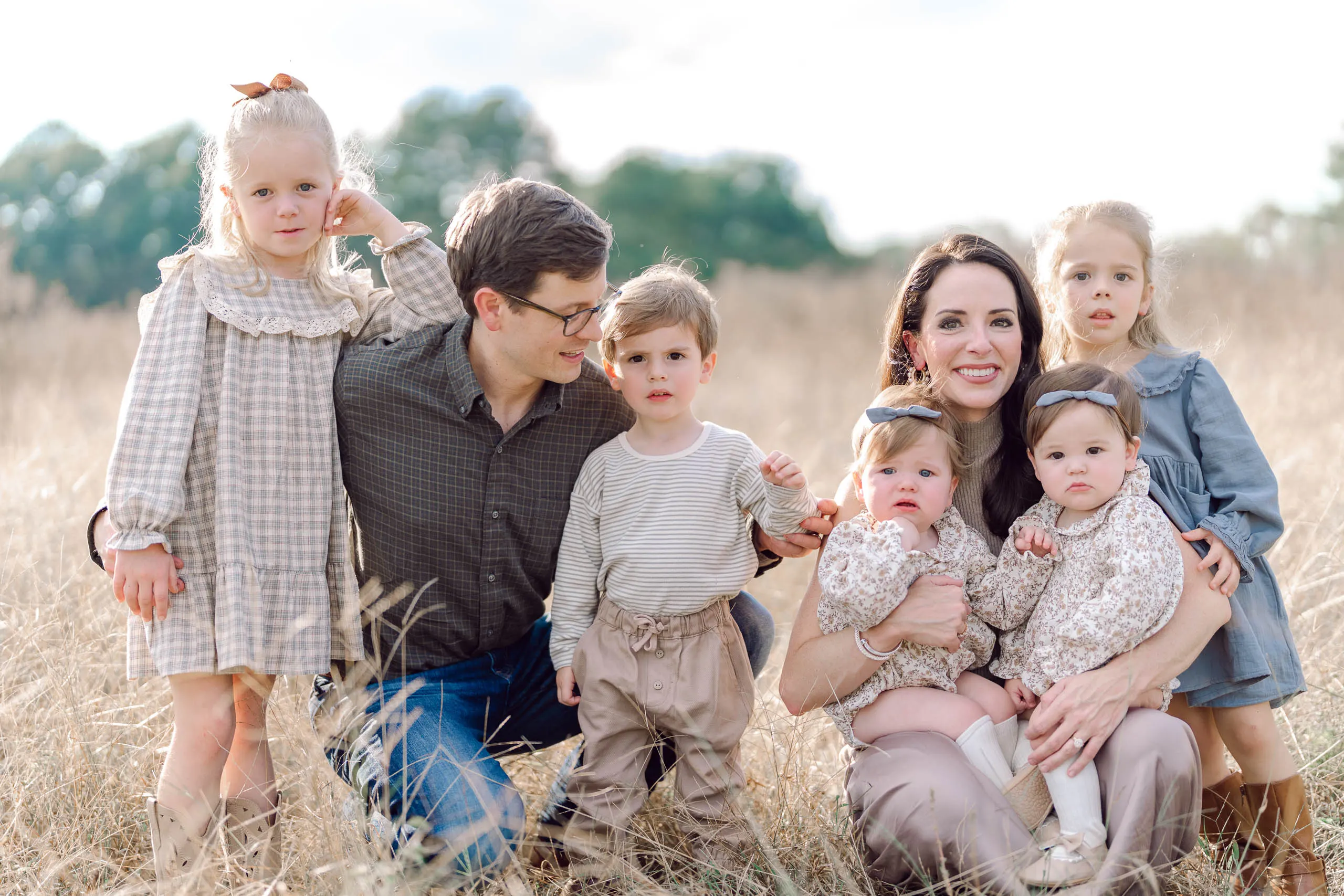 Pinehurst NC family photographer Pasha Belman Photography photographing a family of seven sitting together in tall golden grass