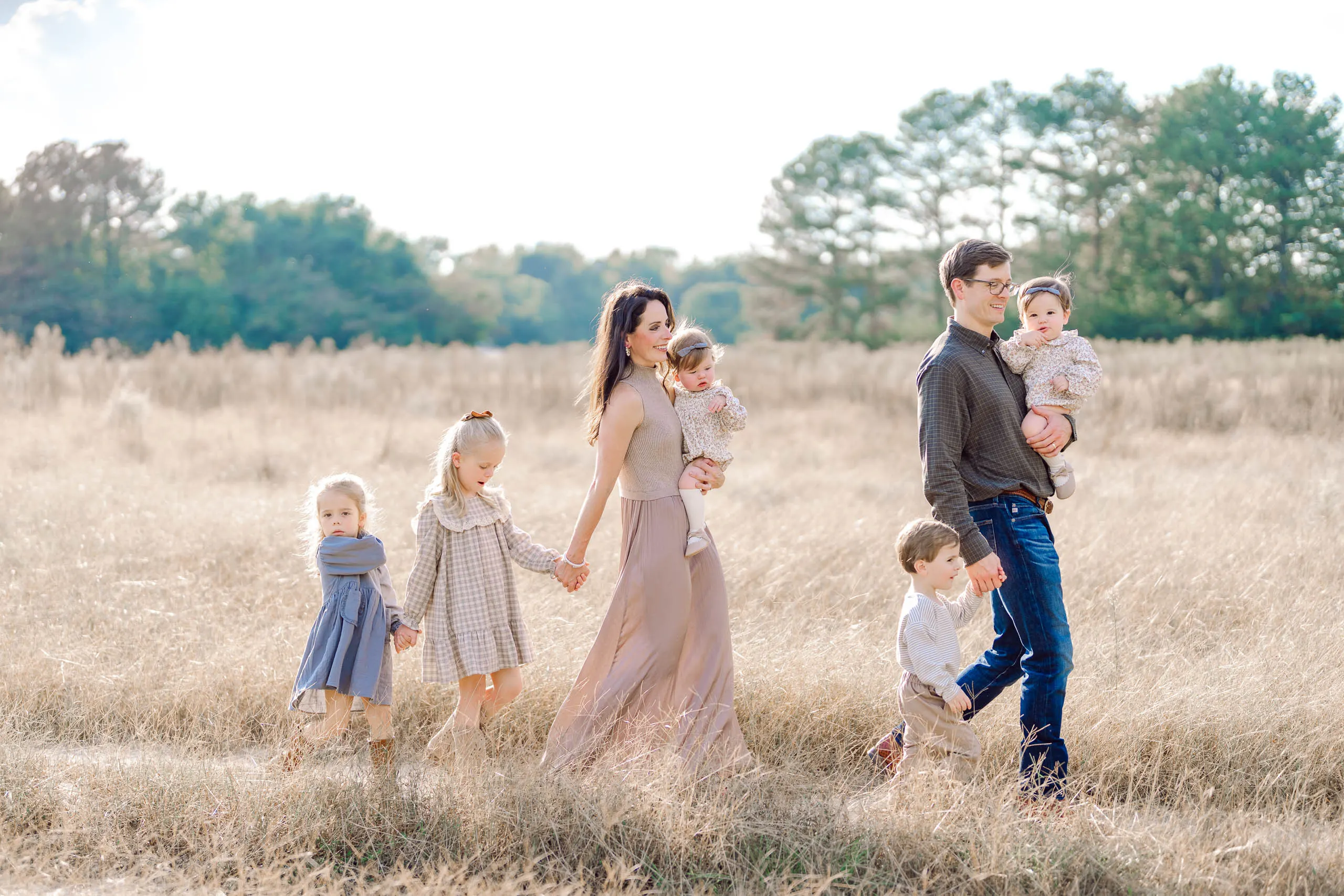 Family walking together through an open field in Pinehurst, North Carolina