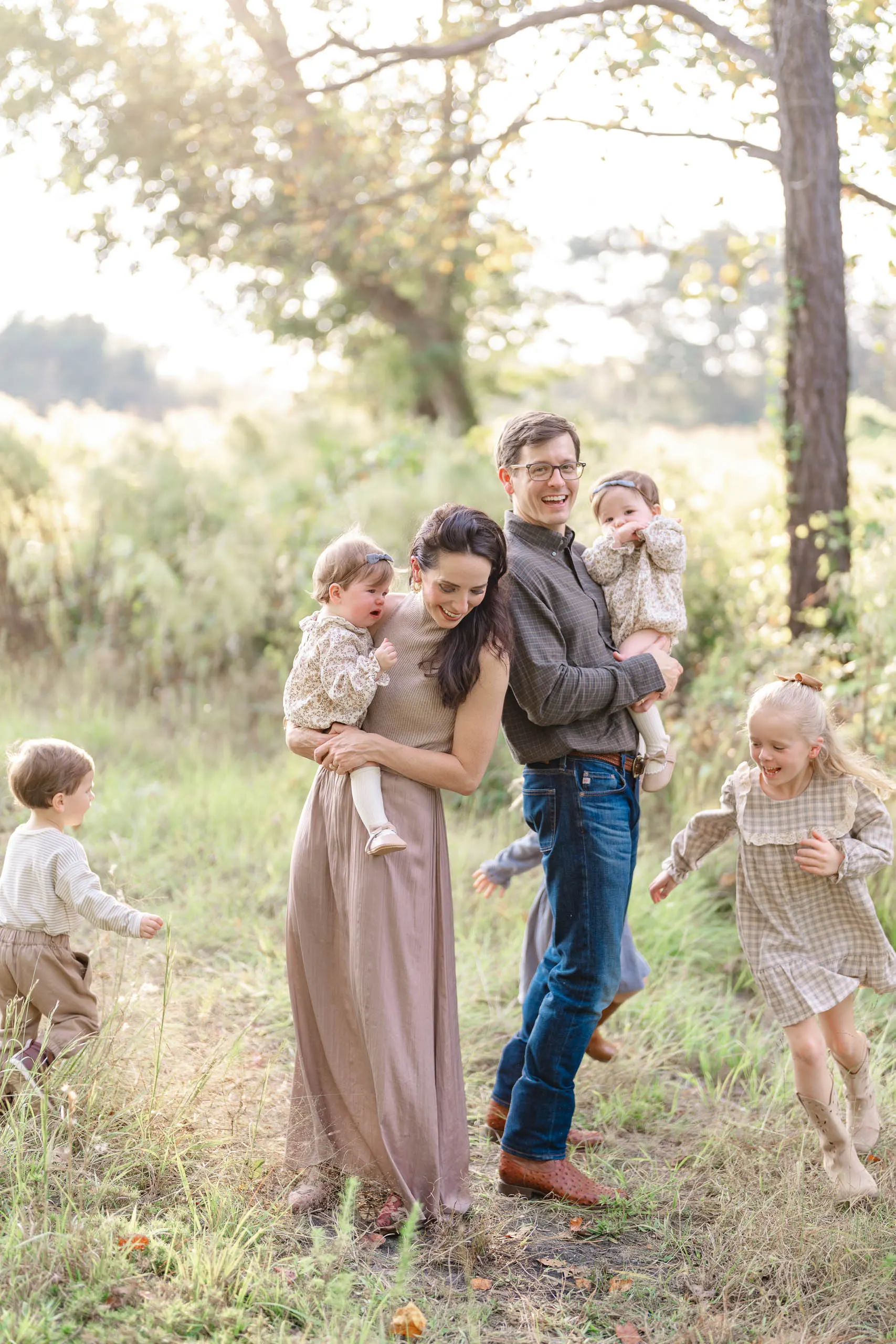 Mother and father with their children laughing together in a green field