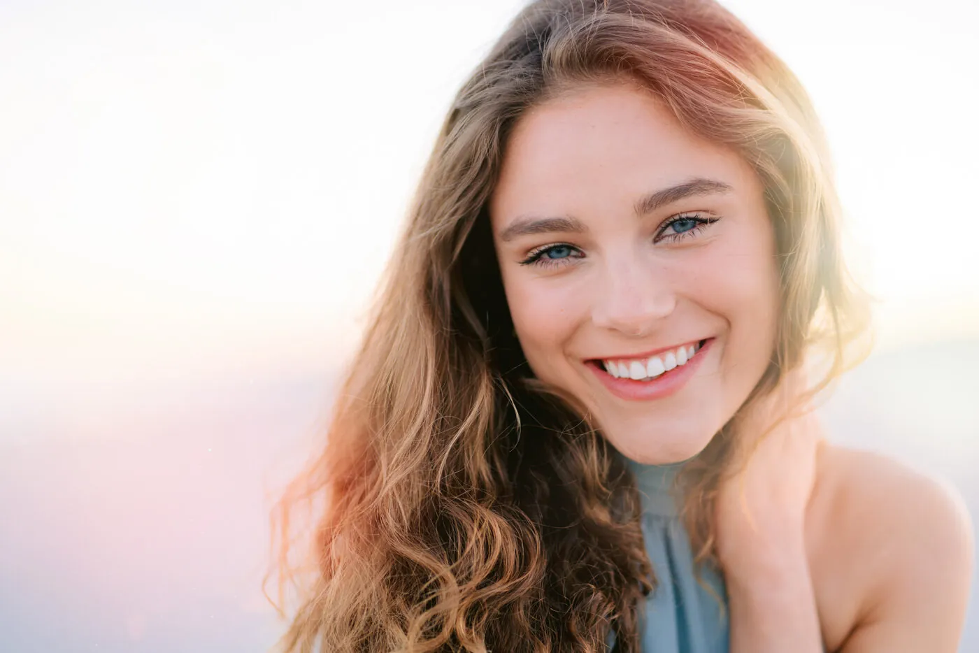 Close portrait of a smiling young woman with long glowing hair, a portrait and personal branding photograph by Myrtle Beach photographer Pasha Belman